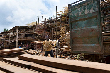 A wood seller at MonteÌe Parc Market africa,people,man,men,horizontal,timber,market,markets,commercial,cameroon,yaounde,wood market,seller,work,wood,deforestation