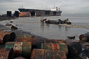 An oil tanker graveyard coast,coastal,coastline,beach,litter,trash,pollution,human impact,waste,tide,tidal,landscape,shipping,tanker,barrels,oil barrel,oil drum,oil,industry